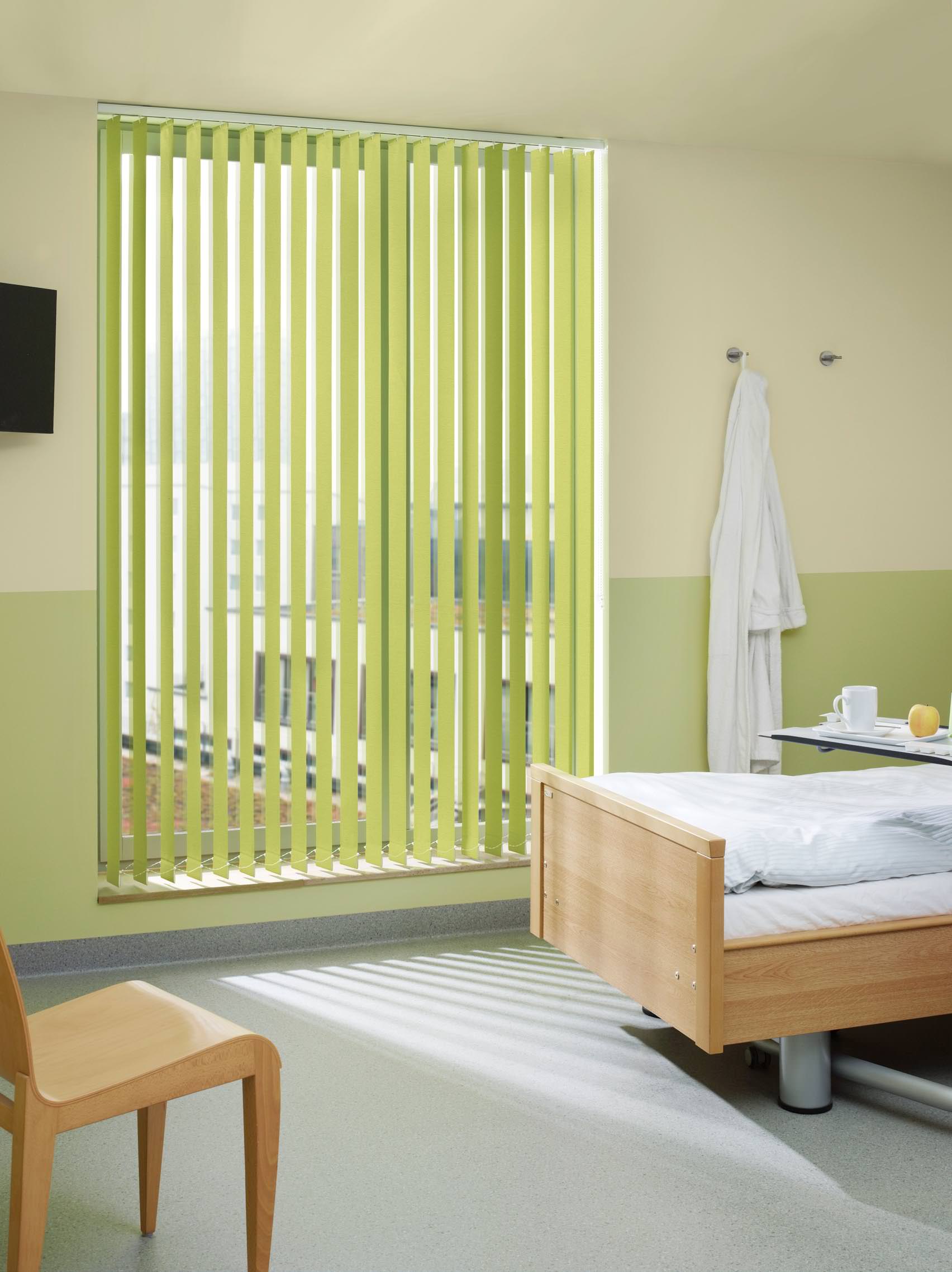 Heller grüner Lamellenvorhang in einem freundlichen Wohnraum – frische Farbe und funktionaler Sonnenschutz.