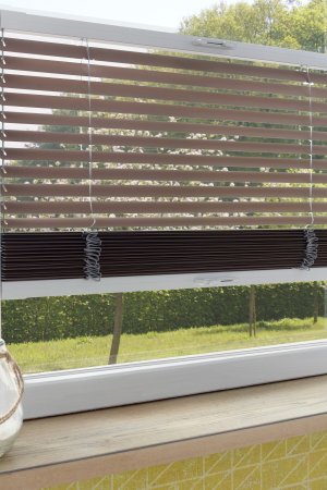 Braune Jalousie am Fenster mit Gartenblick, stufenlos regulierbarer Lichteinfall.