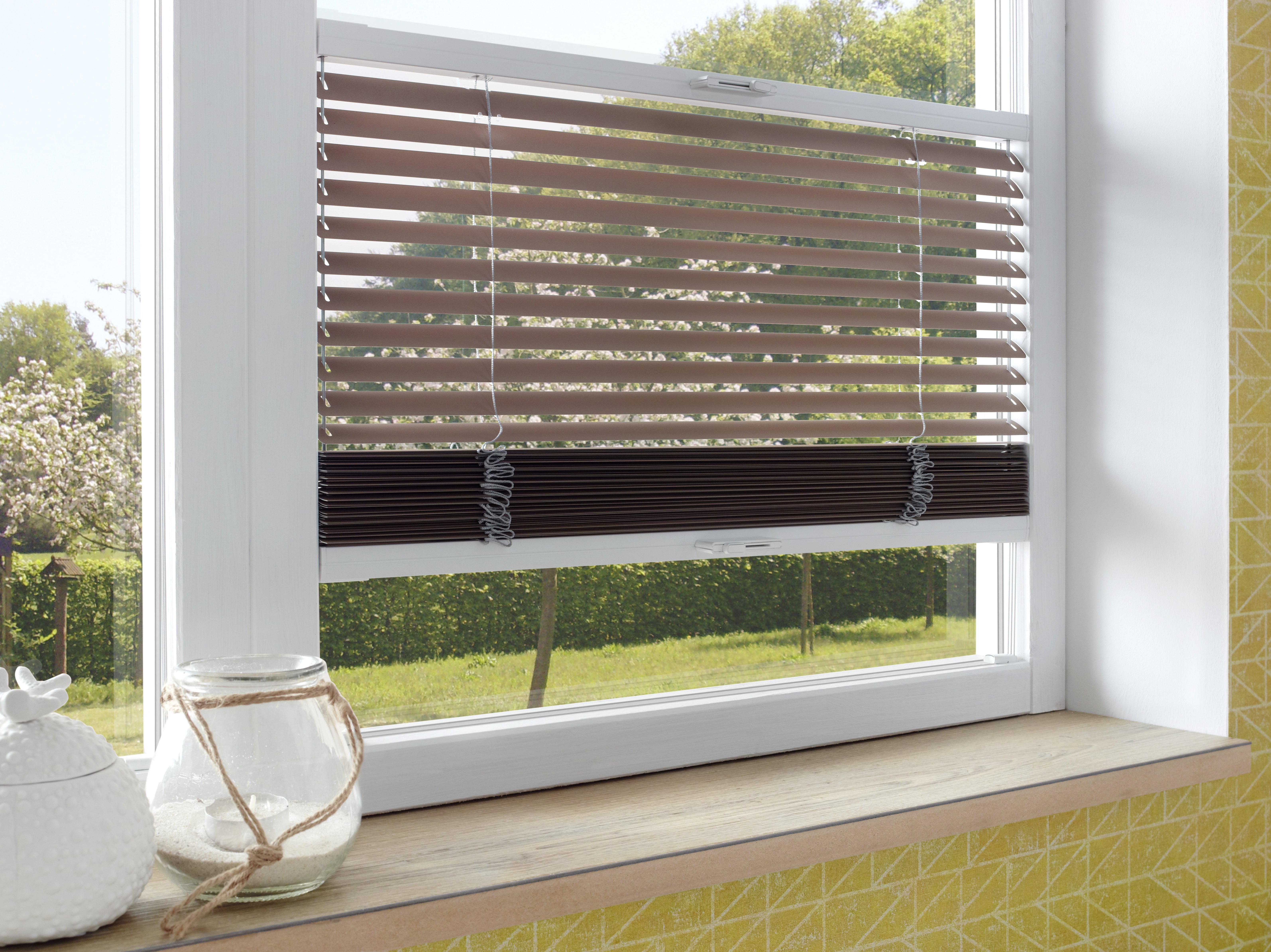Braune Jalousie am Fenster mit Gartenblick, stufenlos regulierbarer Lichteinfall.